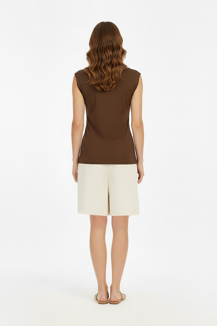 Blusa con drapeado lateral y broche dorado